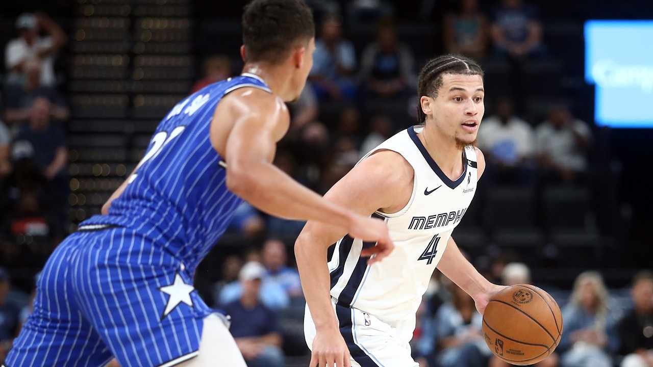 Memphis Grizzlies guard Walter Clayton Jr. dribbles with his left hand as an Orlando Magic defender guards him.