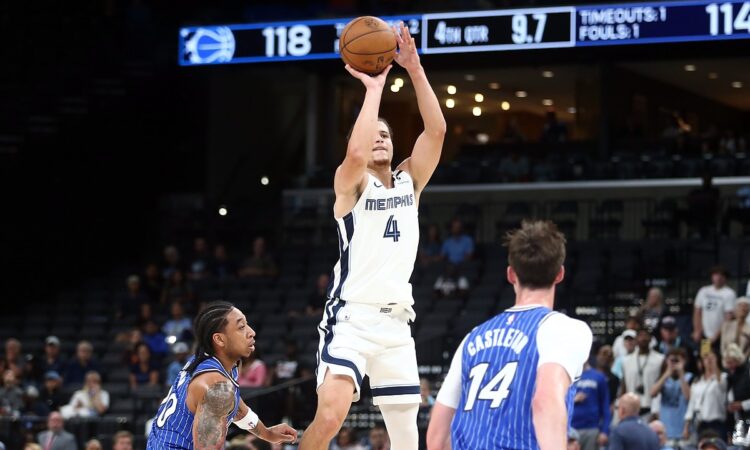 Memphis Grizzlies guard Walter Clayton Jr. rises for a jump shot as two Orlando Magic defenders look on.