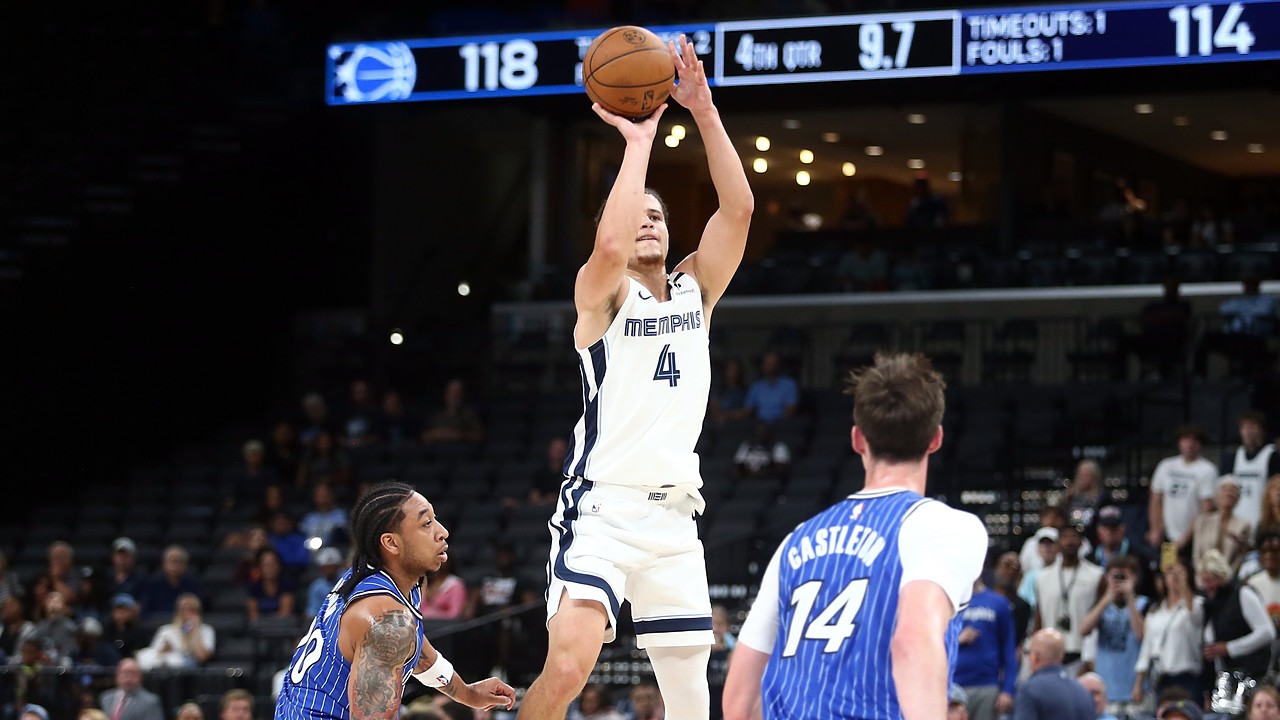 Memphis Grizzlies guard Walter Clayton Jr. rises for a jump shot as two Orlando Magic defenders look on.