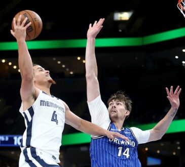 Memphis Grizzlies guard Walter Clayton Jr. rises for a one-handed layup as Orlando Magic center Colin Castleton reaches to contest.
