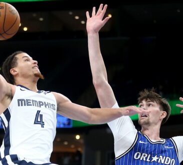 Memphis Grizzlies guard Walter Clayton Jr. rises for a one-handed layup as Orlando Magic center Colin Castleton reaches to contest.