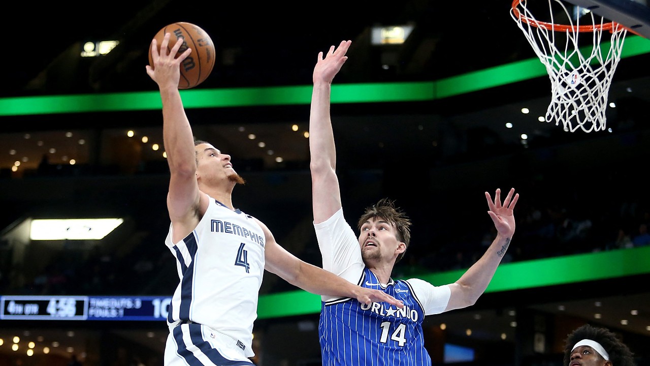 Memphis Grizzlies guard Walter Clayton Jr. rises for a one-handed layup as Orlando Magic center Colin Castleton reaches to contest.