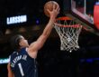 Dallas Mavericks guard Walter Clayton Jr., seen from behind, extends one hand toward the rim with the ball.