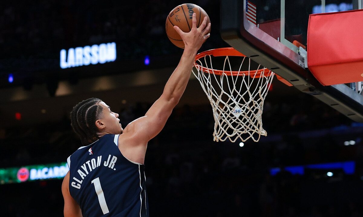 Dallas Mavericks guard Walter Clayton Jr., seen from behind, extends one hand toward the rim with the ball.