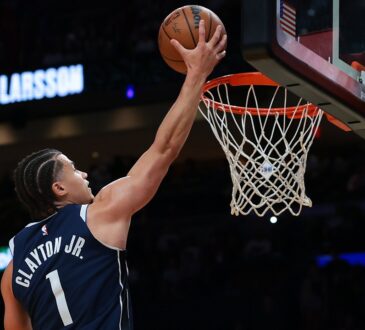 Dallas Mavericks guard Walter Clayton Jr., seen from behind, extends one hand toward the rim with the ball.