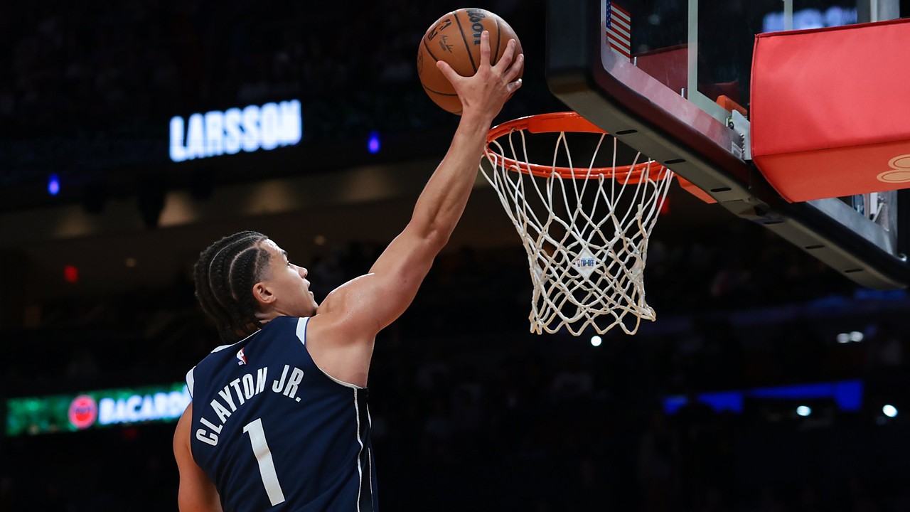 Dallas Mavericks guard Walter Clayton Jr., seen from behind, extends one hand toward the rim with the ball.