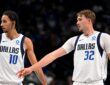 Dallas Mavericks forwards Zaccharie Risacher and Cooper Flagg look on as Flagg extends an arm toward Risacher.