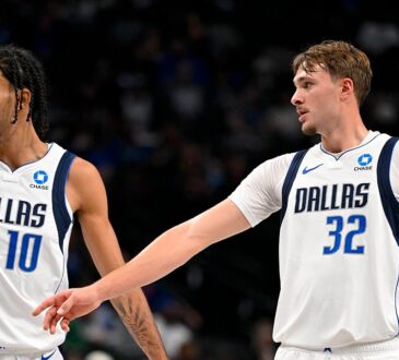 Dallas Mavericks forwards Zaccharie Risacher and Cooper Flagg look on as Flagg extends an arm toward Risacher.