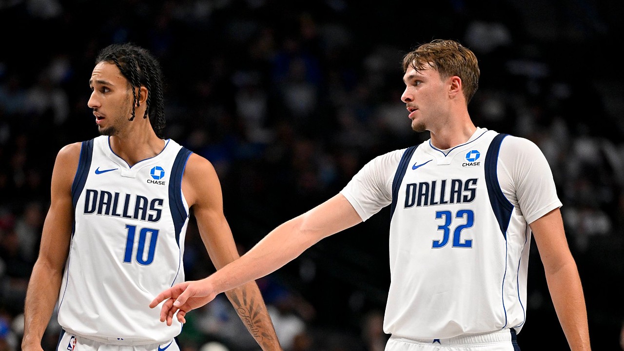 Dallas Mavericks forwards Zaccharie Risacher and Cooper Flagg look on as Flagg extends an arm toward Risacher.