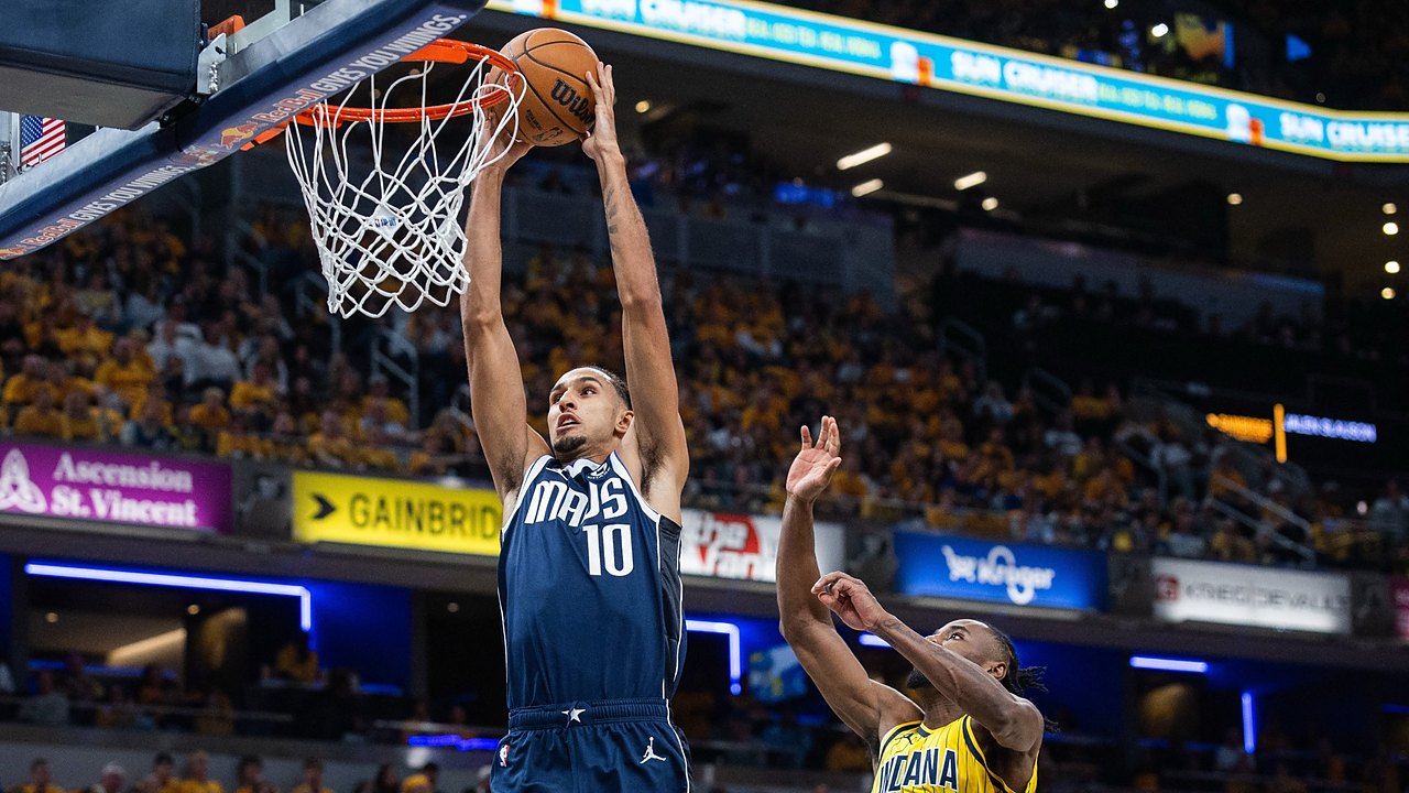 Dallas Mavericks forward Zaccharie Risacher dunks with both hands as Indiana Pacers guard Aaron Nesmith leaps to contest.